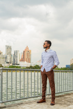 Portrait of handsome young black businessman at park outdoors during summerの写真素材