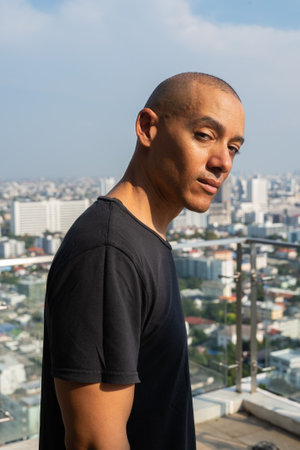 Portrait of handsome bald man wearing t-shirt against plain backgroundの写真素材