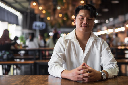 Portrait of Handsome Young Asian Man Sitting in Coffee Shop Restaurant Conceptの写真素材