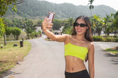 Young beautiful Asian fitness woman outdoors during summerの写真素材