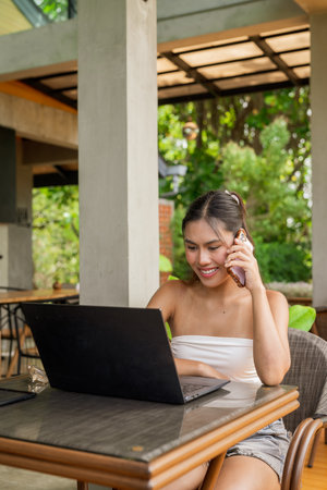 Young woman working on laptop in the restaurantの写真素材