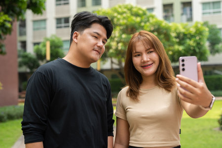 Young happy Asian couple outdoors in parkの写真素材