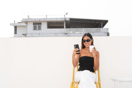 Beautiful Asian woman outdoors during sunny day wearing sunglassesの写真素材