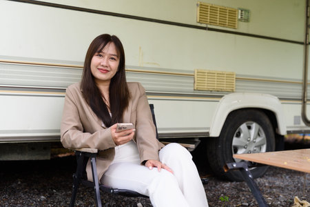 Young Asian woman camping in rv car while travelingの写真素材