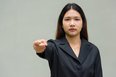 Portrait of young Asian businesswoman against plain backgroundの写真素材