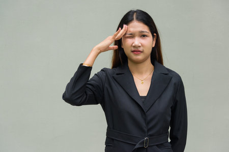 Portrait of young Asian businesswoman against plain background