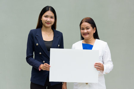 Portrait of mother and daughter against plain wall backgroundの写真素材
