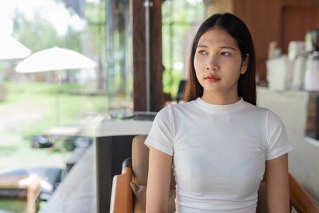 Portrait of beautiful Asian woman in cafe wearing white shirtの写真素材