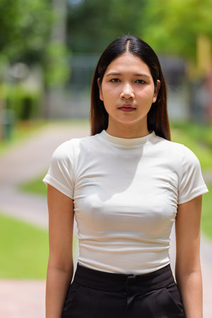 Portrait of Asian woman outdoors in park during sunny dayの写真素材
