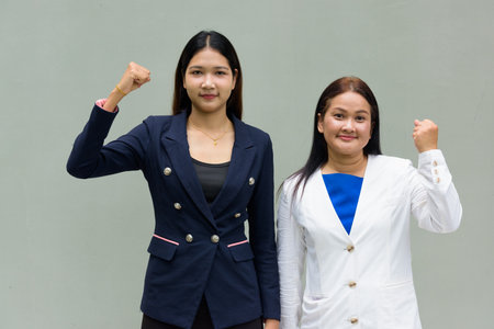 Portrait of mother and daughter against plain wall backgroundの写真素材