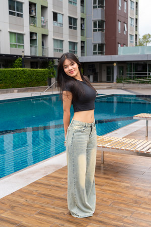 Young beautiful Asian woman relaxing next to swimming pool during summerの写真素材