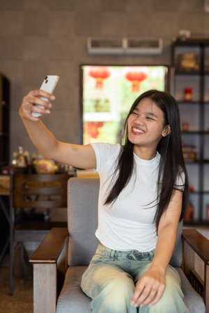Portrait of young beautiful Asian woman relaxing inside traditional Asian house