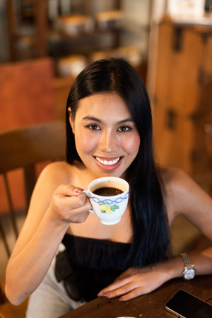 Portrait of young beautiful Asian woman in coffee shop