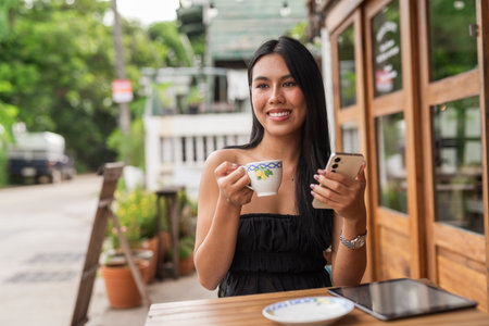 Portrait of young beautiful Asian woman in coffee shopの写真素材