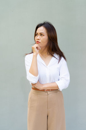 Portrait of beautiful Asian businesswoman against plain wall backgroundの写真素材