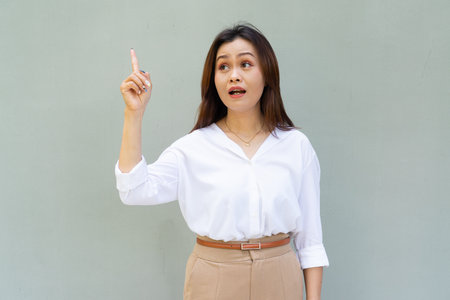 Portrait of beautiful Asian businesswoman against plain wall backgroundの写真素材