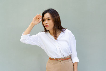 Portrait of beautiful Asian businesswoman against plain wall backgroundの写真素材