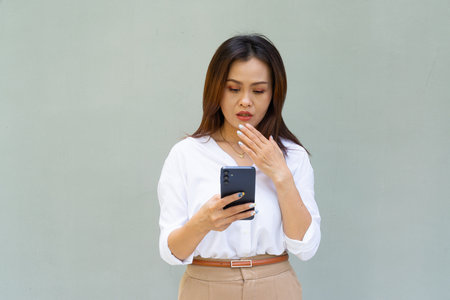 Portrait of beautiful Asian businesswoman against plain wall backgroundの写真素材