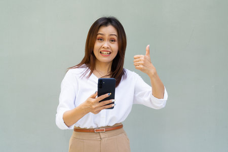 Portrait of beautiful Asian businesswoman against plain wall backgroundの写真素材
