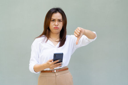 Portrait of beautiful Asian businesswoman against plain wall backgroundの写真素材