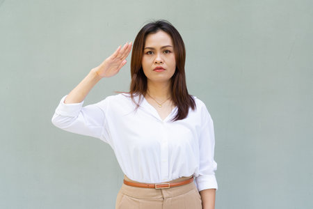 Portrait of beautiful Asian businesswoman against plain wall backgroundの写真素材