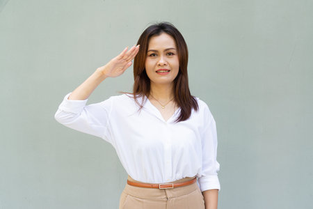 Portrait of beautiful Asian businesswoman against plain wall backgroundの写真素材