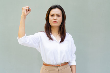 Portrait of beautiful Asian businesswoman against plain wall backgroundの写真素材