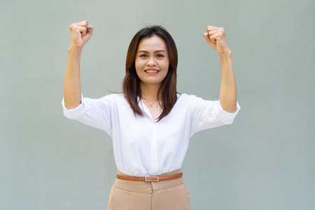 Portrait of beautiful Asian businesswoman against plain wall backgroundの写真素材