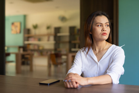 Portrait of beautiful Asian woman sitting in libraryの写真素材