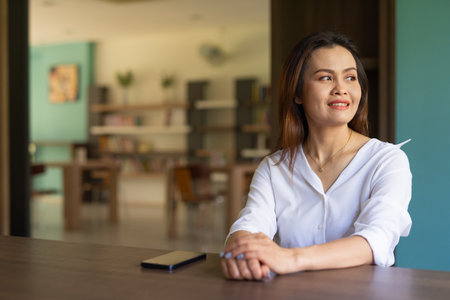 Portrait of woman sitting in libraryの写真素材