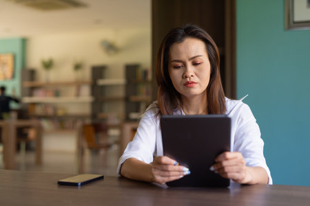 Portrait of beautiful Asian woman sitting in libraryの写真素材