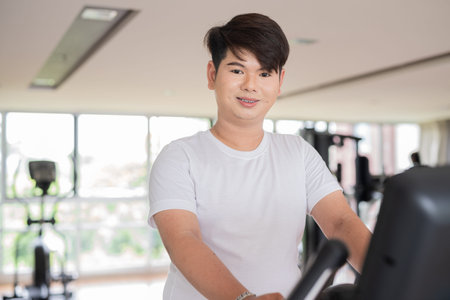 Young cute gay man athlete exercising in fitness gym during dayの写真素材
