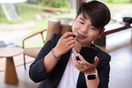 Young cute gay man makeup artist businessman in coffee shop restaurant wearing business clothesの写真素材