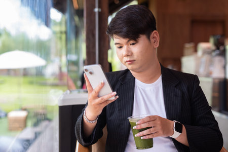 Young cute gay man makeup artist businessman in coffee shop restaurant wearing business clothes