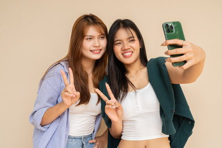 Portrait of two young women against plain wallの写真素材