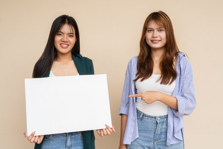 Portrait of two young women against plain wallの写真素材