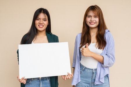 Portrait of two young women against plain wallの写真素材