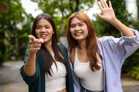 Two young woman together in park during summerの写真素材