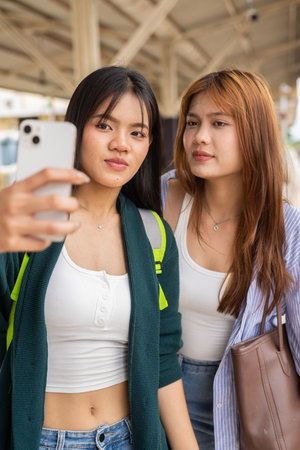 Portrait of two young Asian woman at train station togetherの写真素材
