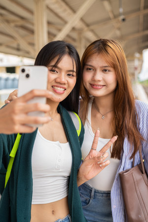 Portrait of two young Asian woman at train station together