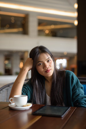 Young beautiful Asian woman sitting in cafe restaurant