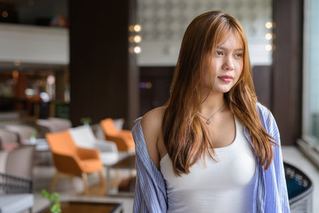 Portrait of beautiful young Asian woman in cafe restaurantの写真素材