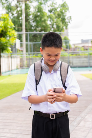 Asian Schoolboy Relaxing in Park After Classの写真素材