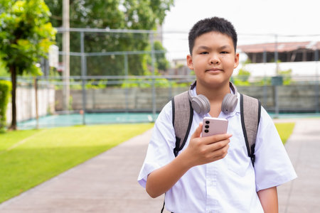 Asian Schoolboy Relaxing in Park After Classの写真素材