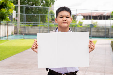 Asian Schoolboy Relaxing in Park After Classの写真素材