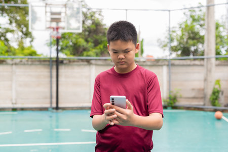 Asian Teenage Boy on Basketball Court in Sportswearの写真素材