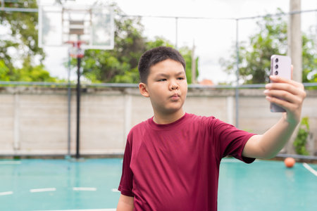 Asian Teenage Boy on Basketball Court in Sportswearの写真素材