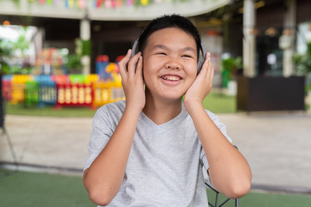 Teenage boy listening music with headphones outdoorsの写真素材