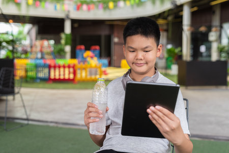 Young teenager student boy using digital tablet computer outdoorsの写真素材