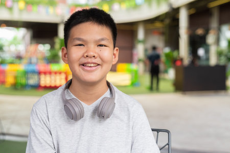 Portrait of Asian teenage boy with headphones looking at cameraの写真素材